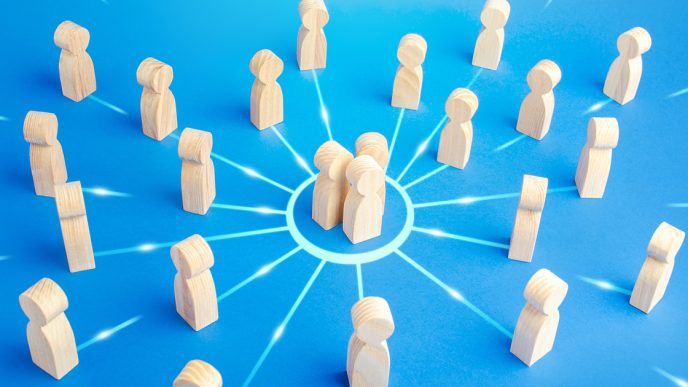 Wooden figures grouped inside a circle and standing outside