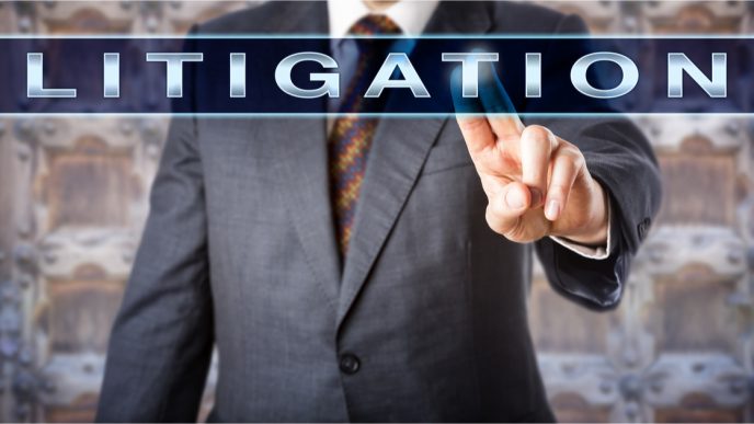 Businessman tapping on the screen with Litigation written