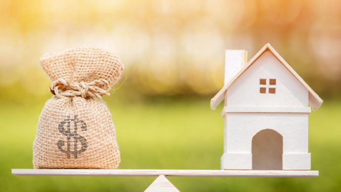 Money bag balanced against home