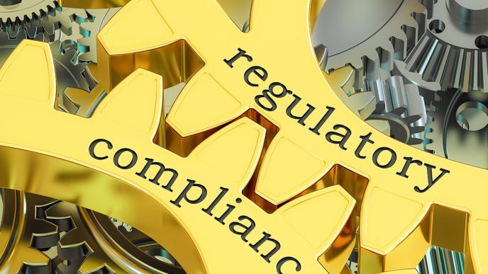 Two gold cogs with regulatory and compliance written on them for ASIC