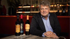 Portrait of Ben Clarke with bottles of wine on a table