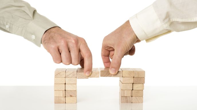 Two hands removing wooden blocks